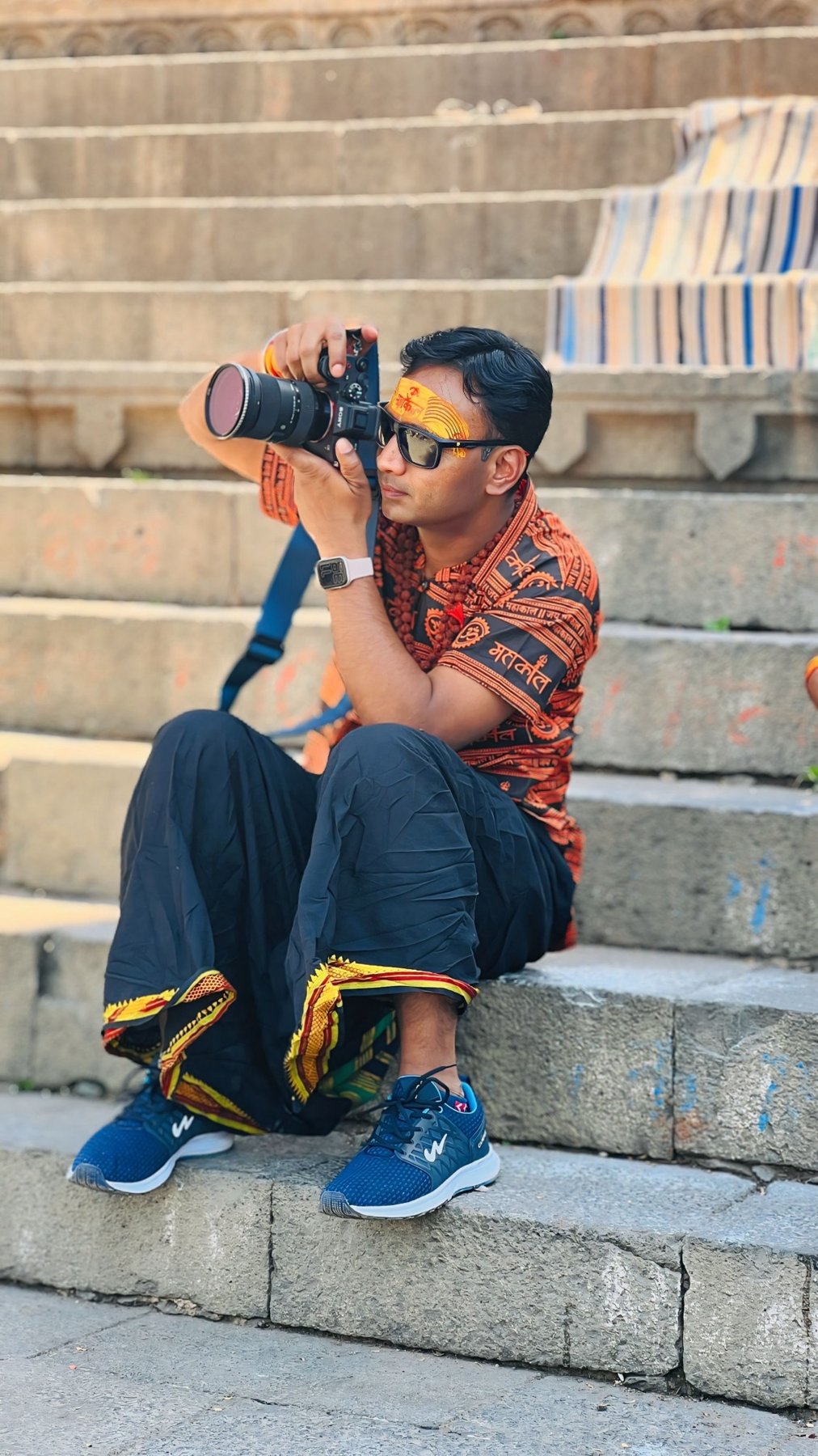 Dr. Vishwanath Bite on temple steps with Sony camera — Varanasi